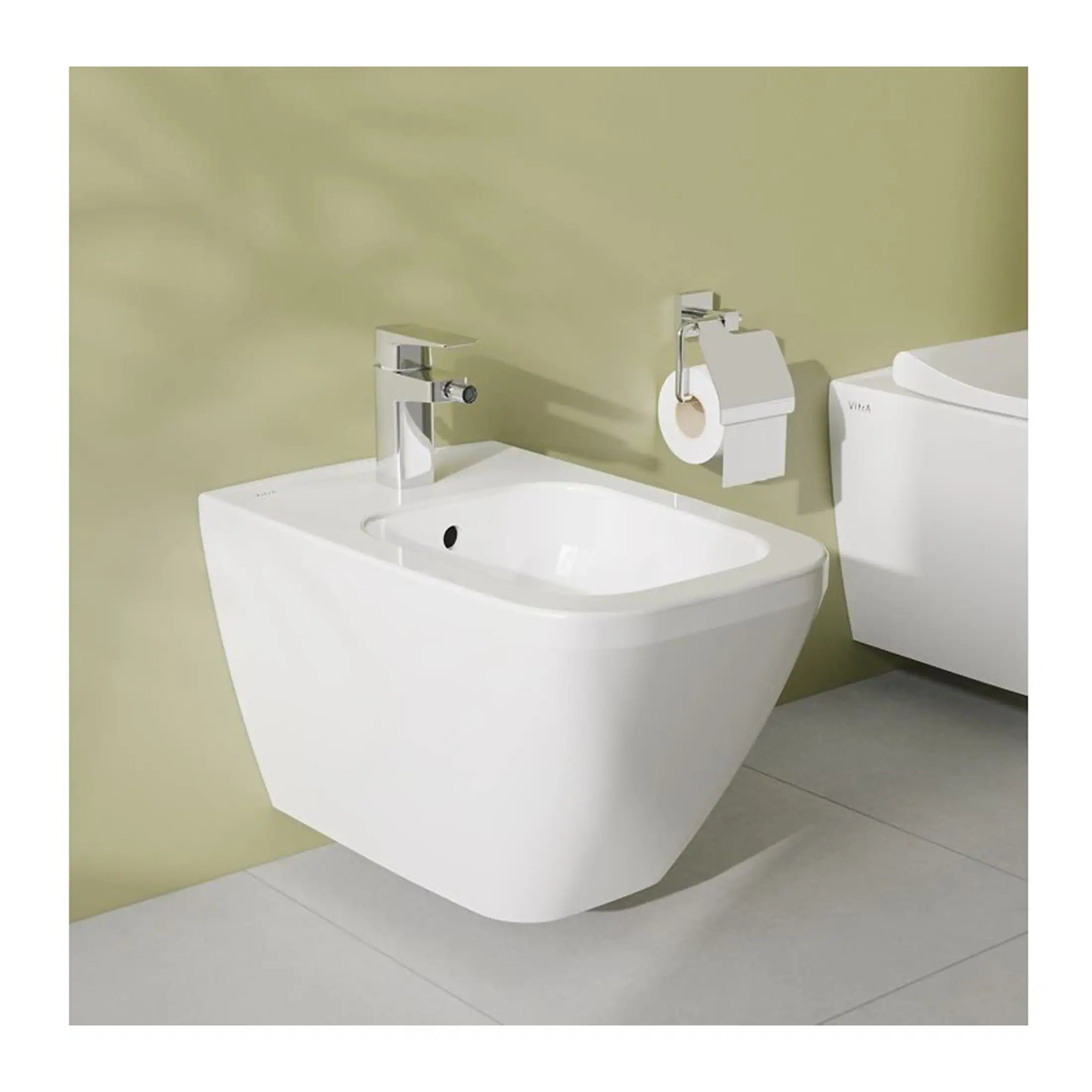 Minimalist wall-mounted bathroom bidet with modern chrome faucet, adjacent toilet with soft-close lid, and contemporary toilet paper holder in a sleek, clean bathroom setting.