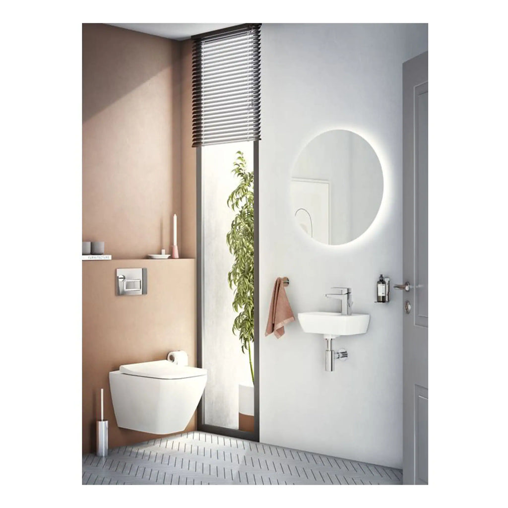 Modern bathroom with wall-hung toilet, minimalist sink, and backlit round mirror, featuring neutral tones and natural light for a sleek, contemporary look. Ideal for stylish, functional bathroom design.