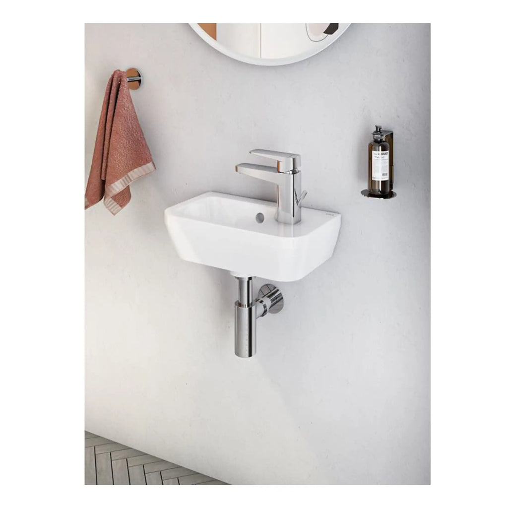 Compact wall-mounted bathroom sink with chrome faucet, ideal for small bathrooms or powder rooms, featuring a tidy design with a matching mirror and accessories.