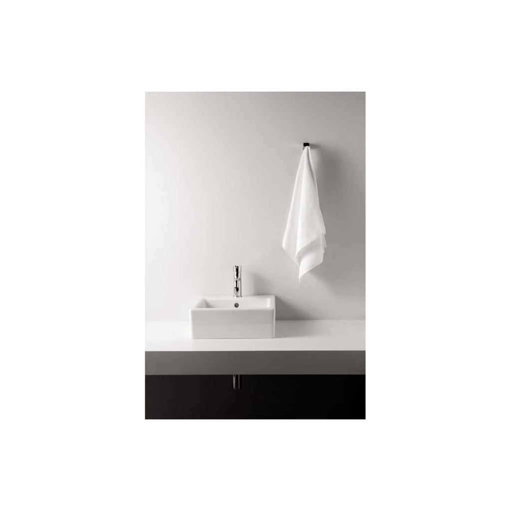 Sleek white bathroom sink with modern chrome faucet and minimalist towel hanging on wall, creating a clean and contemporary bathroom aesthetic for stylish home decor.