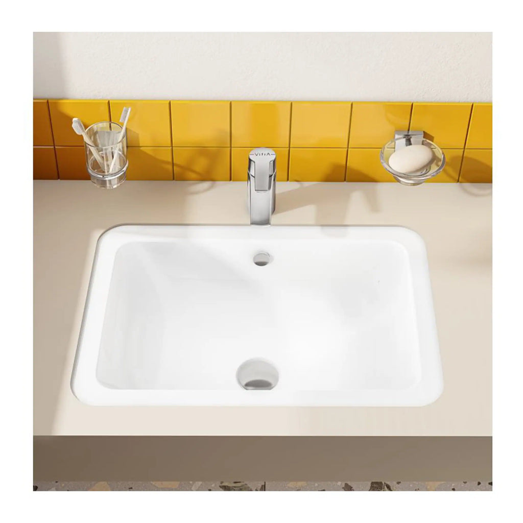 Bright bathroom sink with modern chrome tap, yellow tiled backsplash, toothbrush holder with toothbrushes, soap dish with soap, clean and minimalist bathroom design.