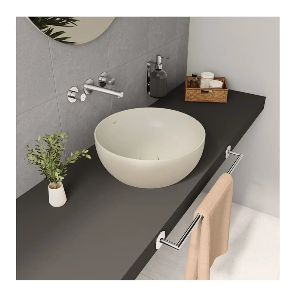 Sleek modern bathroom sink with a rounded white vessel basin on a dark countertop, featuring minimalist wall-mounted tap fixtures, a small potted plant, and bathroom accessories, creating a stylish and functional bathroom space.