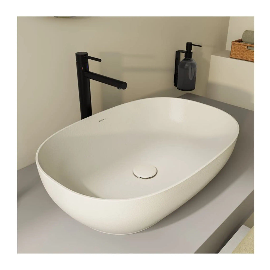 Sleek oval freestanding bathroom sink with modern black faucet and minimalist accessories, ideal for contemporary bathroom designs.