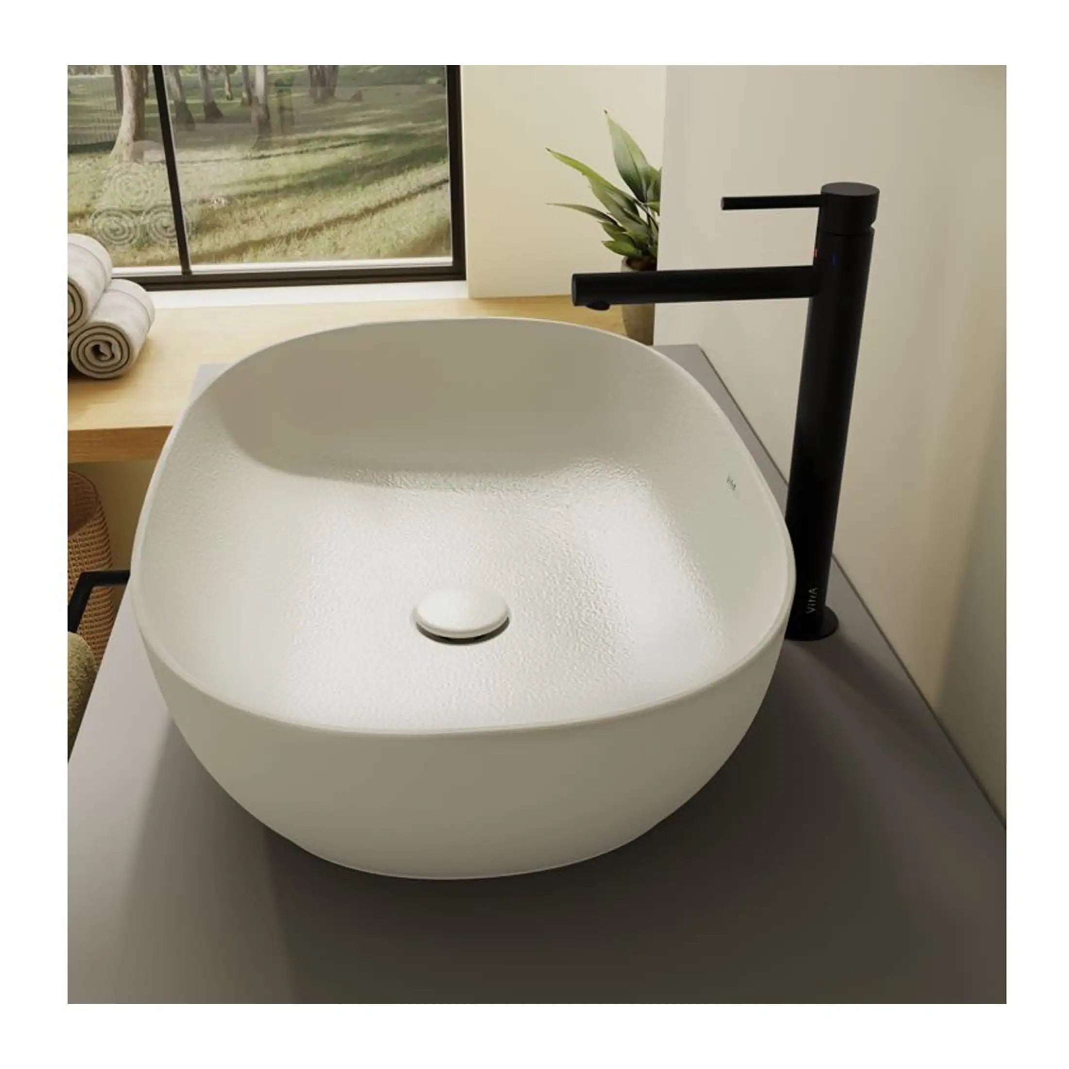 Contemporary white bathroom basin with matte finish and black modern faucet in minimalist bathroom setting, natural light, indoor decor, clean design.
