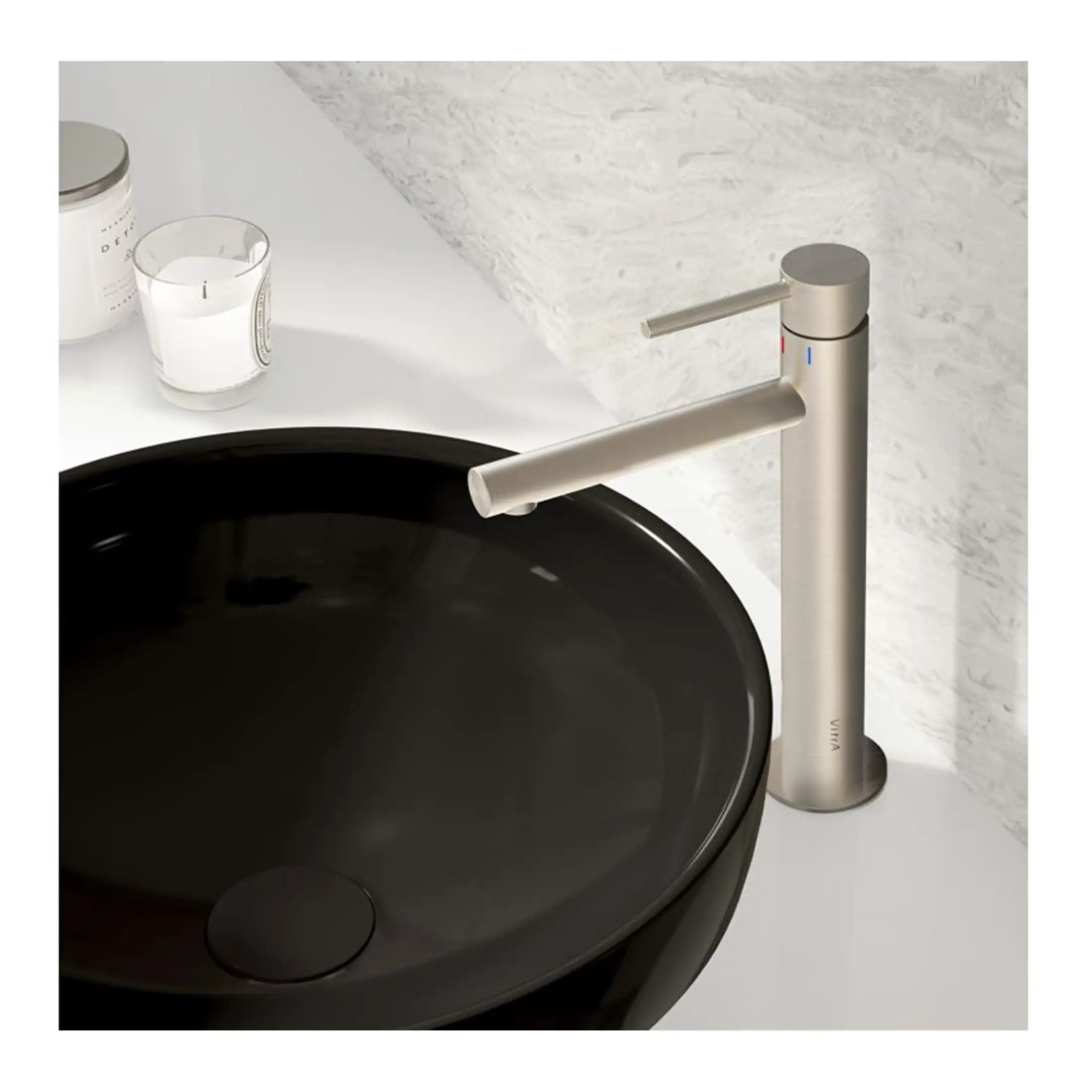 Sleek modern kitchen faucet in brushed stainless steel next to a black vessel sink. Minimalist design with a single lever for temperature control, ideal for contemporary bathroom or kitchen decor.