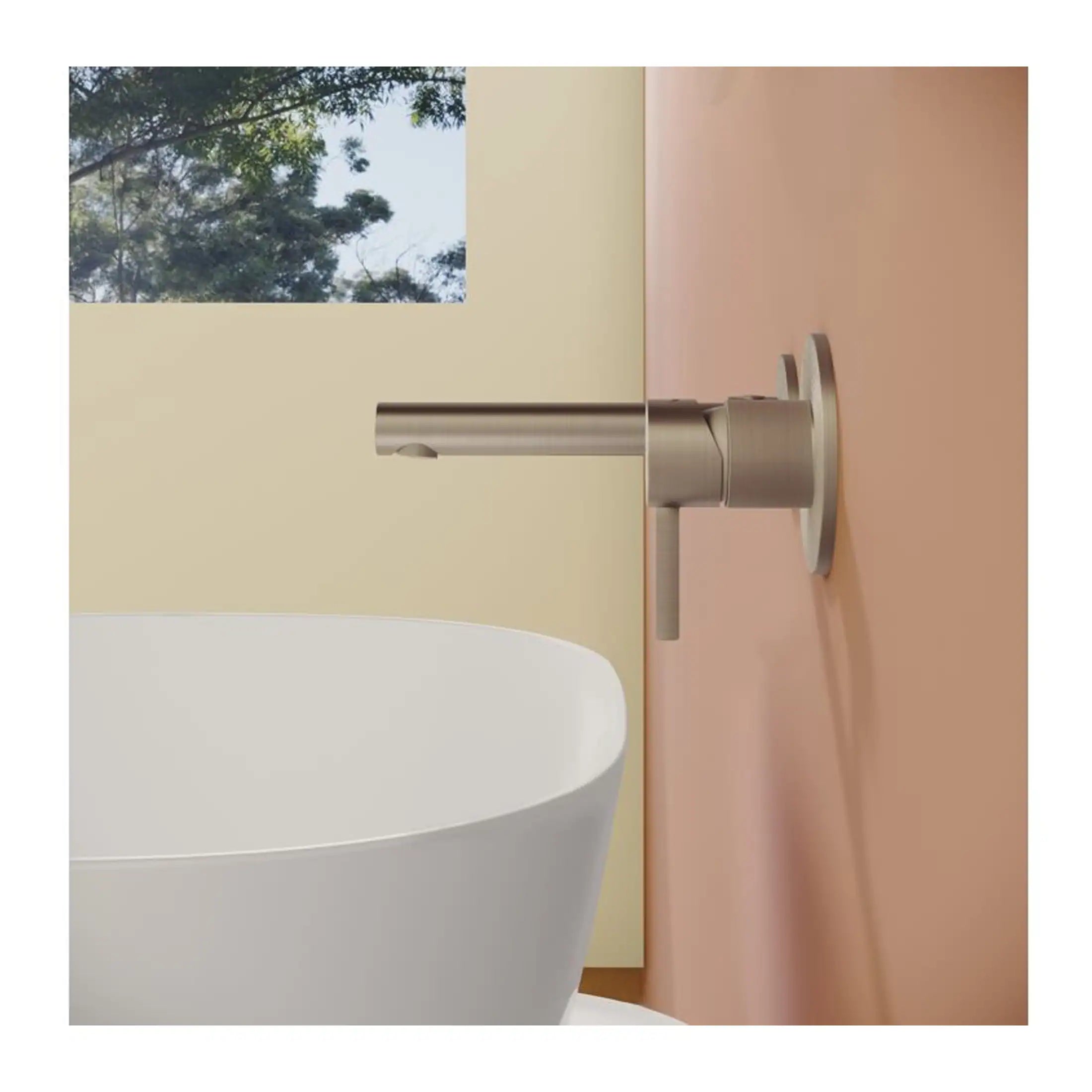 Sleek metallic bathroom faucet mounted on a pastel pink wall, above a modern freestanding white bathtub with a minimalist aesthetic in contemporary bathroom design.