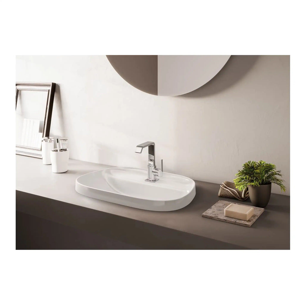 Sleek white bathroom vanity sink with modern chrome faucet, minimalist decor, potted plant, soap dish, and elegant accessories, perfect for contemporary bathroom design.