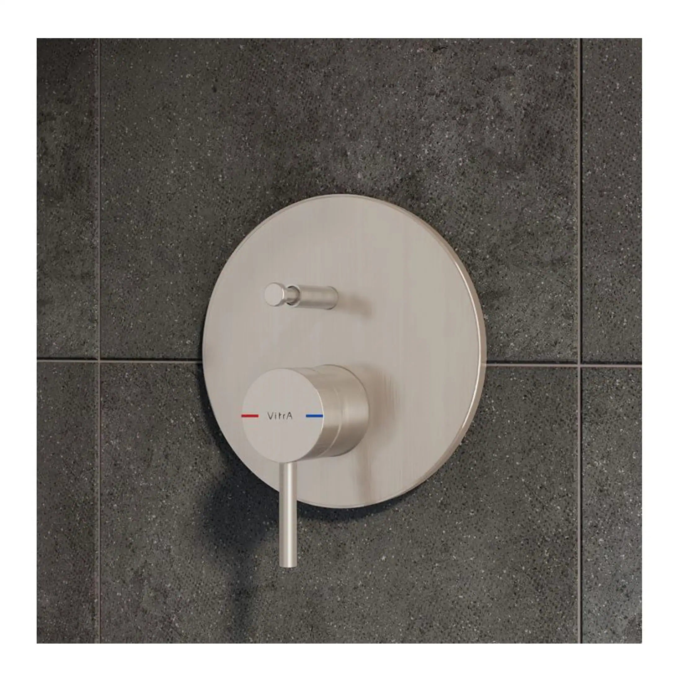 Sleek modern thermostatic shower control with textured brushed stainless steel finish, mounted on dark tiled wall, for precise temperature regulation in contemporary bathrooms.