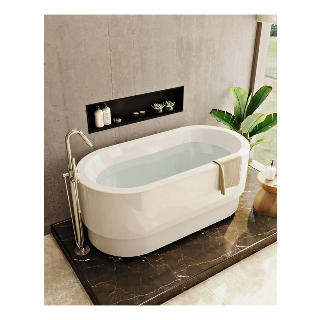 Stylish freestanding white bathtub with modern design, chrome fixtures, and an elegant towel draped over the side, set in a contemporary bathroom with natural light, lush green plant, and minimalist decor.