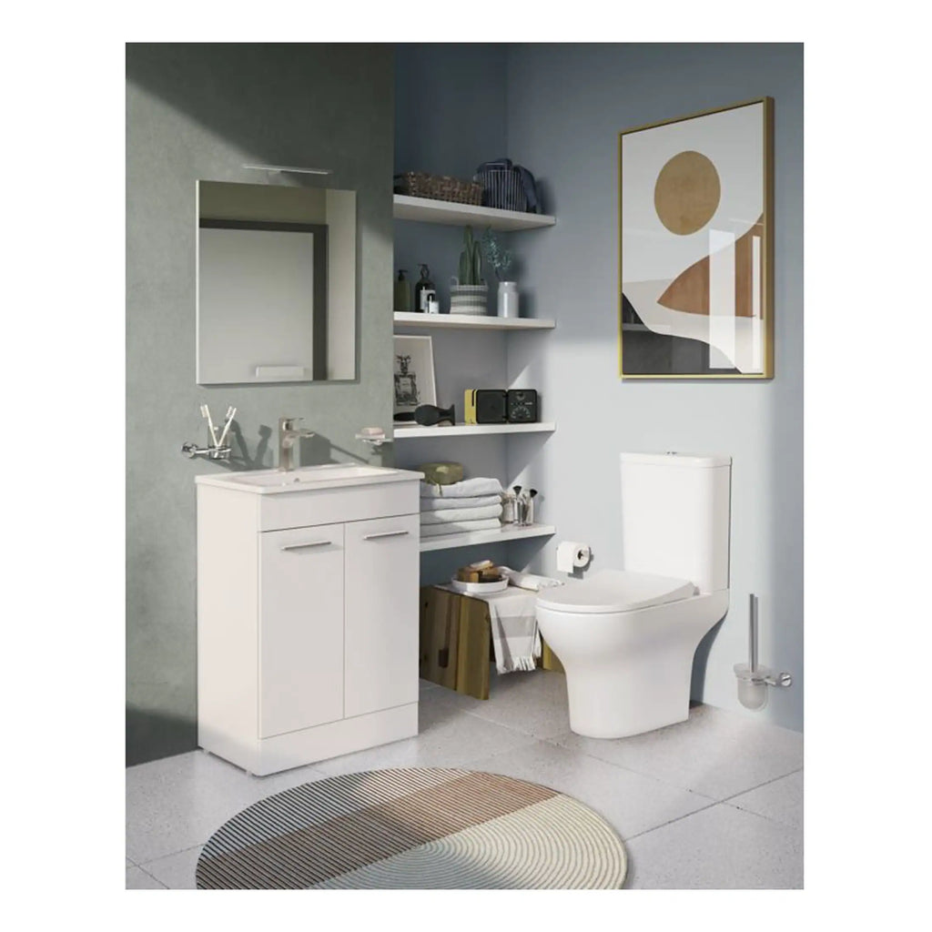 Modern white bathroom vanity with sink, mirror, toilet, and decorative shelves in a contemporary bathroom setting.