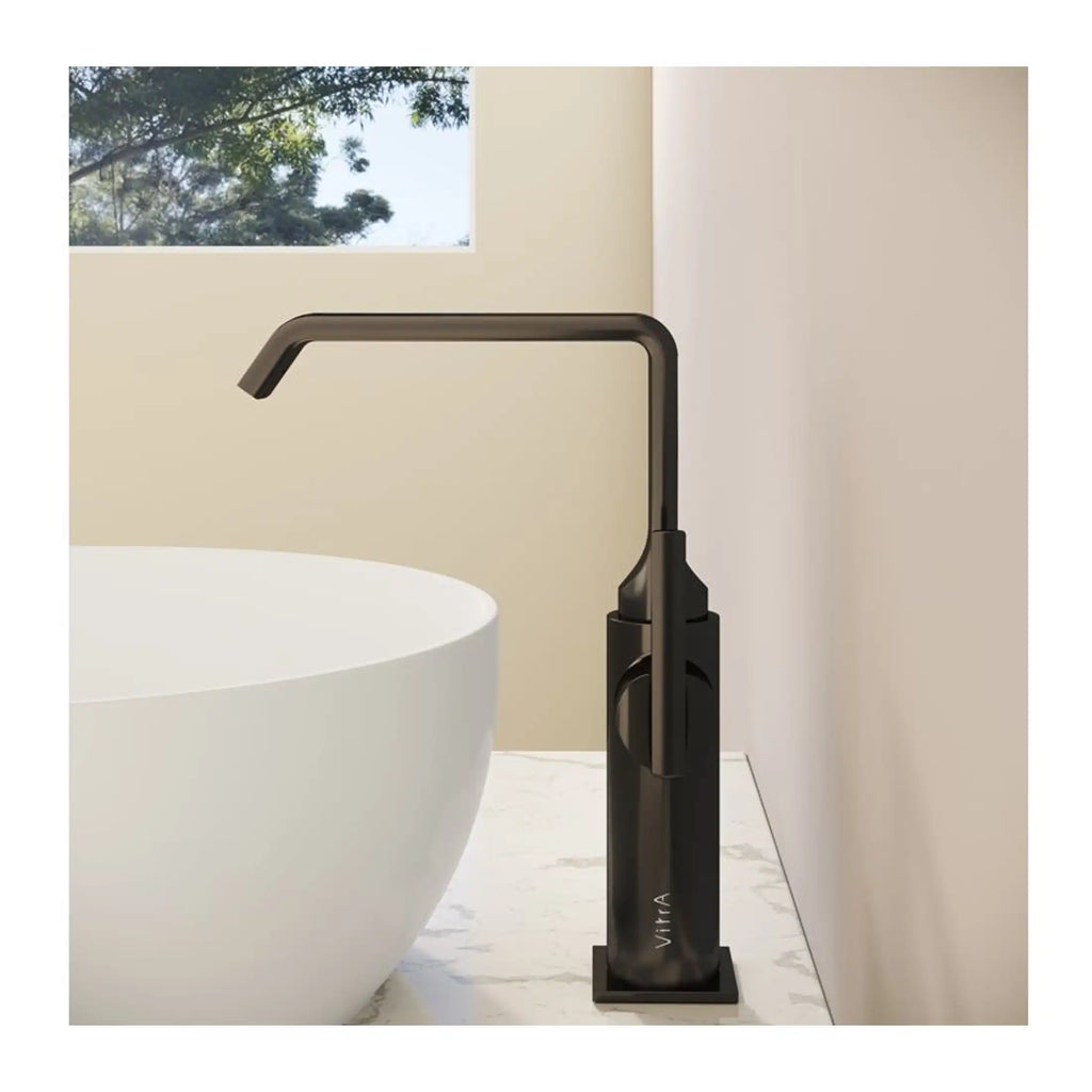 Sleek black freestanding bathroom tap beside modern white bath on marble countertop in contemporary bathroom.