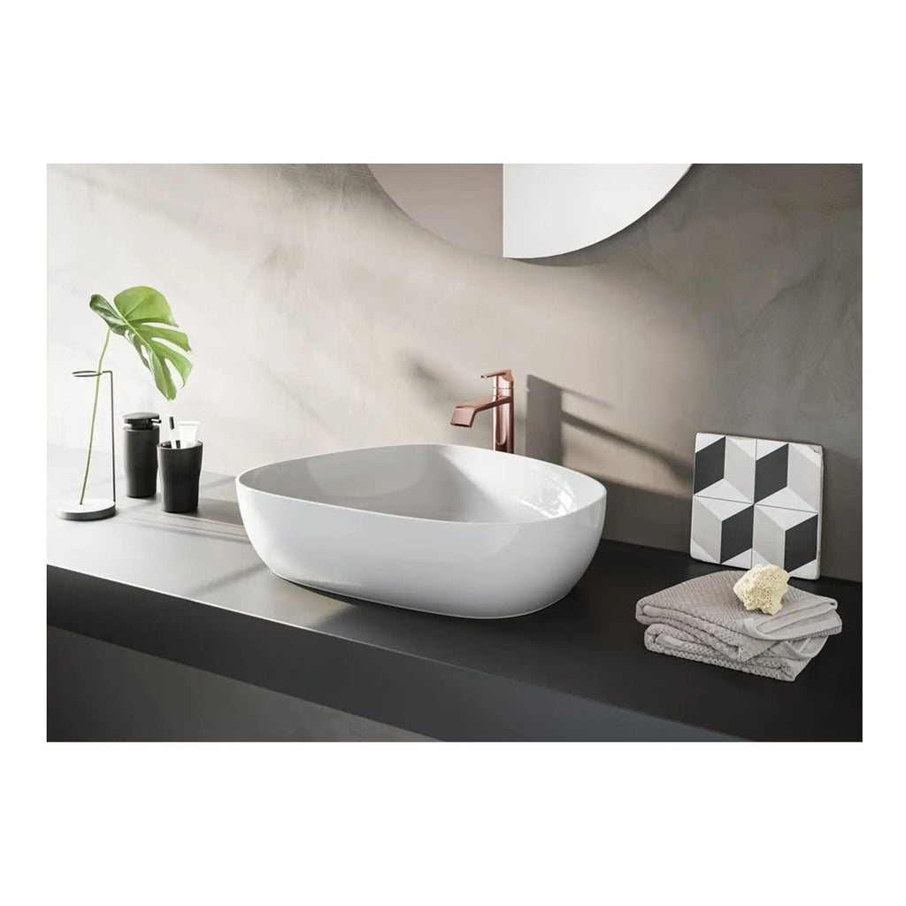 Sleek modern bathroom vanity with a stylish white vessel sink, rose gold faucet, minimalist accessories, and contemporary decor, creating a chic, functional space.