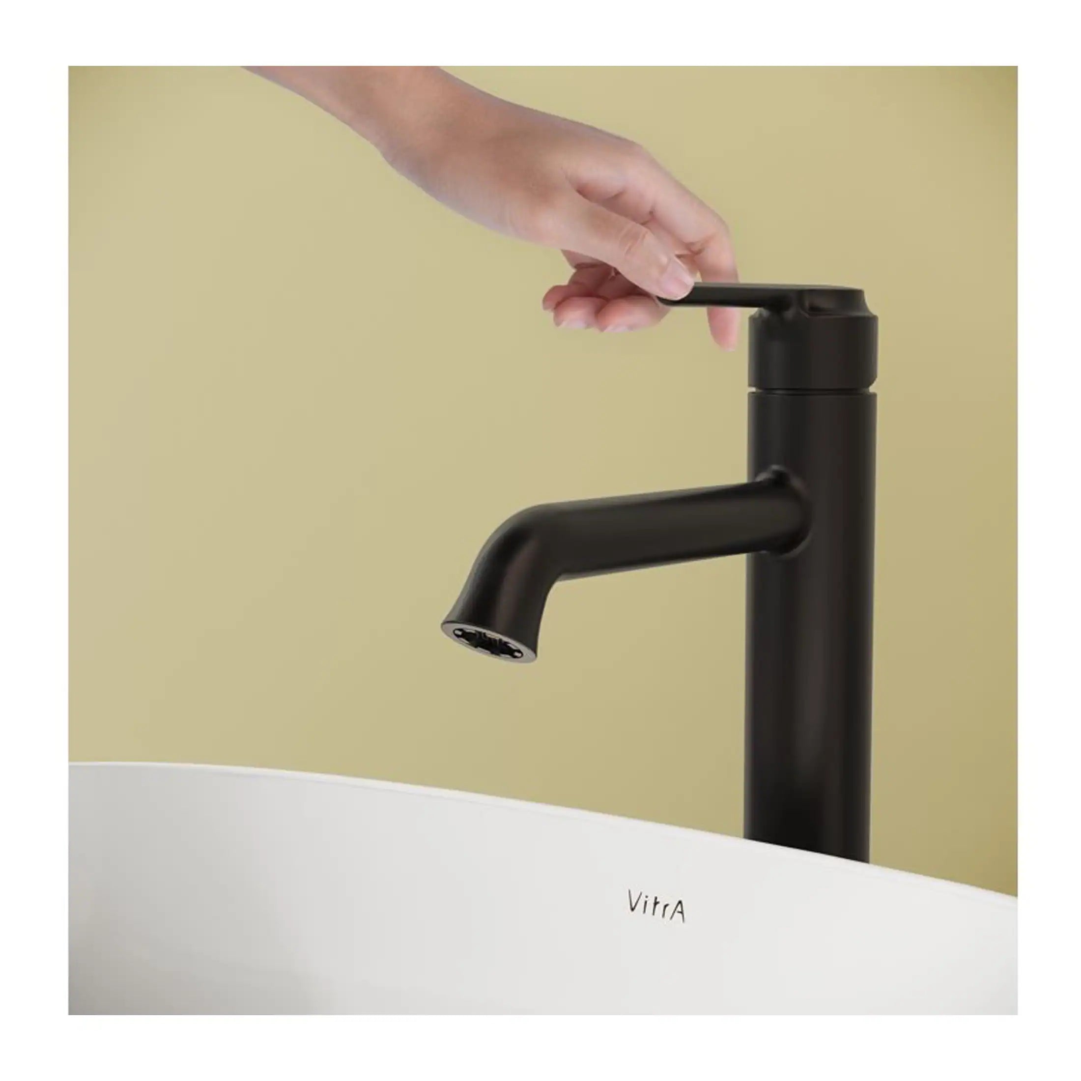 Sleek black kitchen or bathroom tap with modern design, featuring a single lever for easy water control, installed over a stylish white basin with the brand name Vitra.