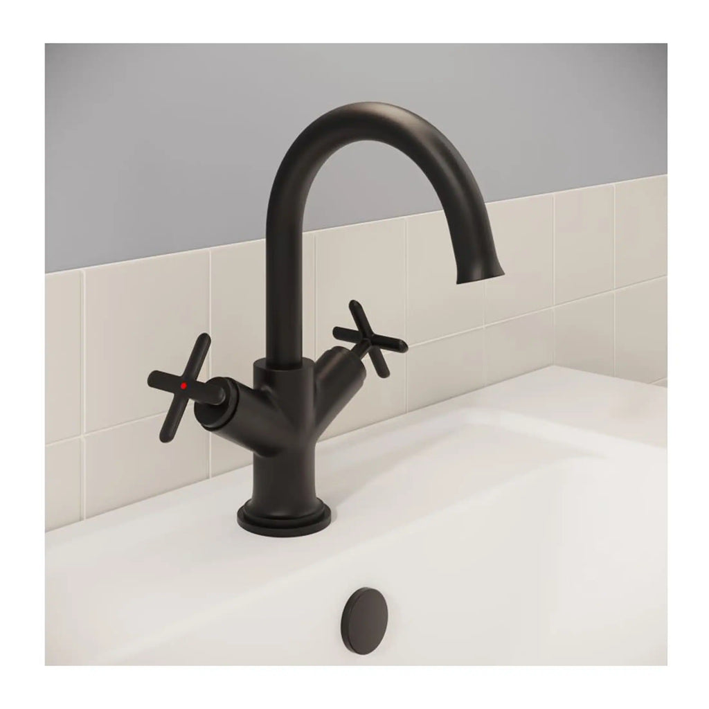 Black matte bathroom mixer tap with cross handles on a white sink and off-white tiled wall.