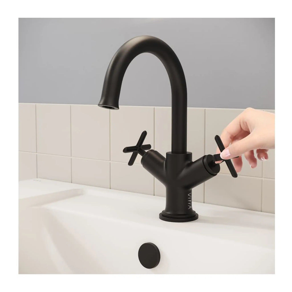 Sleek black kitchen or bathroom mixer tap with dual cross handles, modern design, installed on a white sink with beige tiled backsplash. Perfect for contemporary bathroom or kitchen renovation.