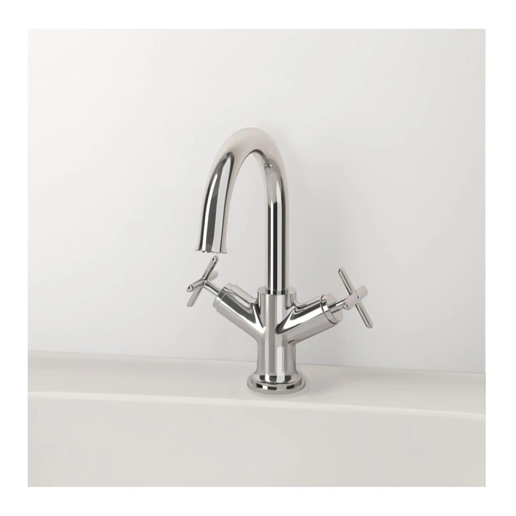 Chrome bathroom mixer tap with dual cross handles on a white bathroom sink.