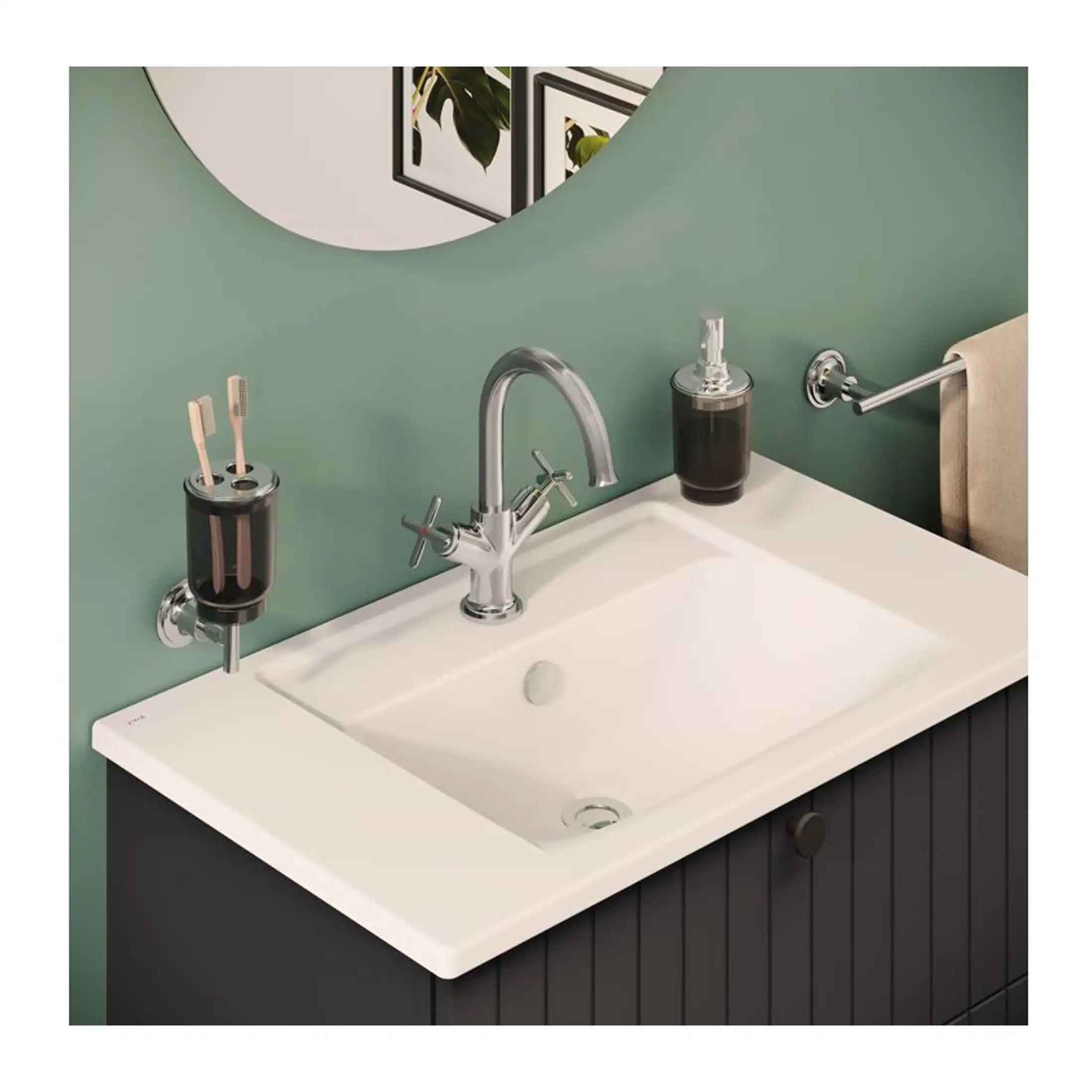 Shiny chrome bathroom tap with side spray and white sink, black storage cabinet, and wall-mounted accessories on a green wall, showcasing modern bathroom design and fixtures.