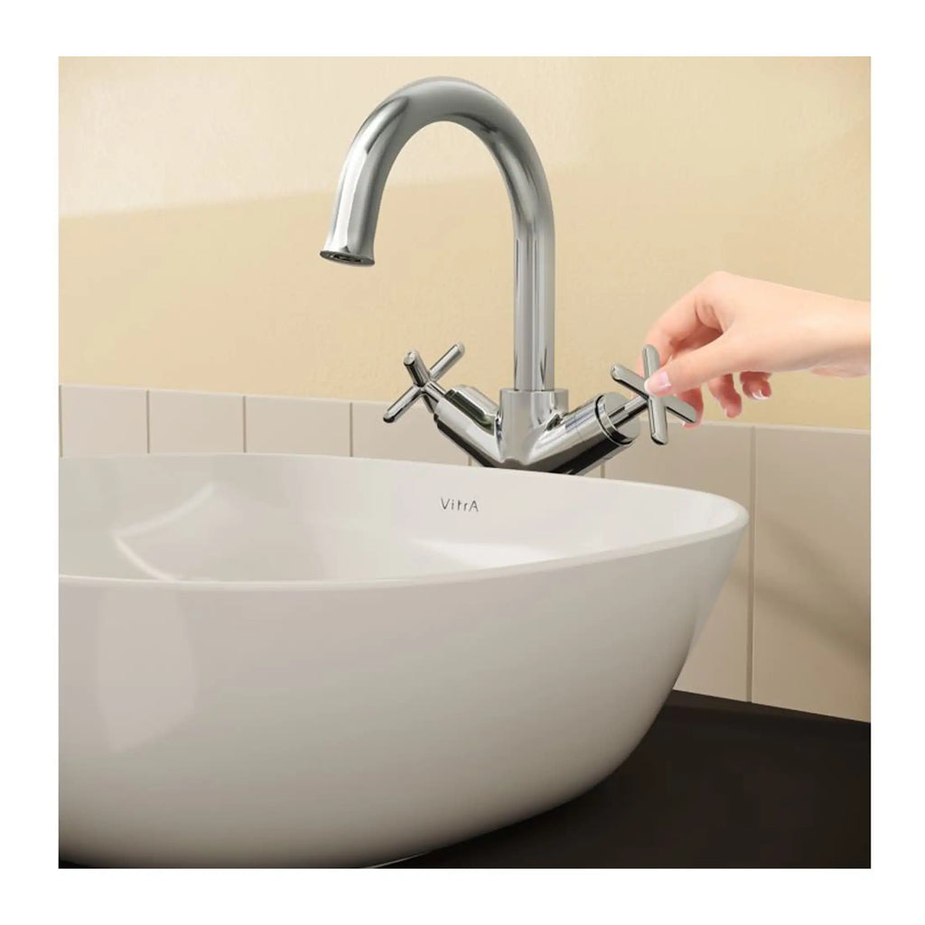 Modern chrome kitchen tap with flexible handles, installed over a white ceramic sink, showcasing contemporary bathroom fixtures and sleek design.