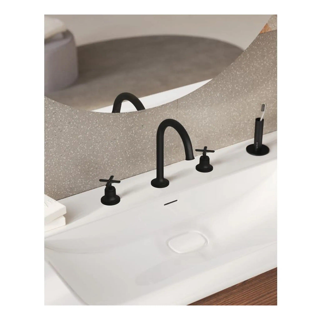 Modern black bathroom taps with minimalist design on a white sink, featuring a textured beige privacy screen and a toothbrush holder, perfect for contemporary bathroom decor.