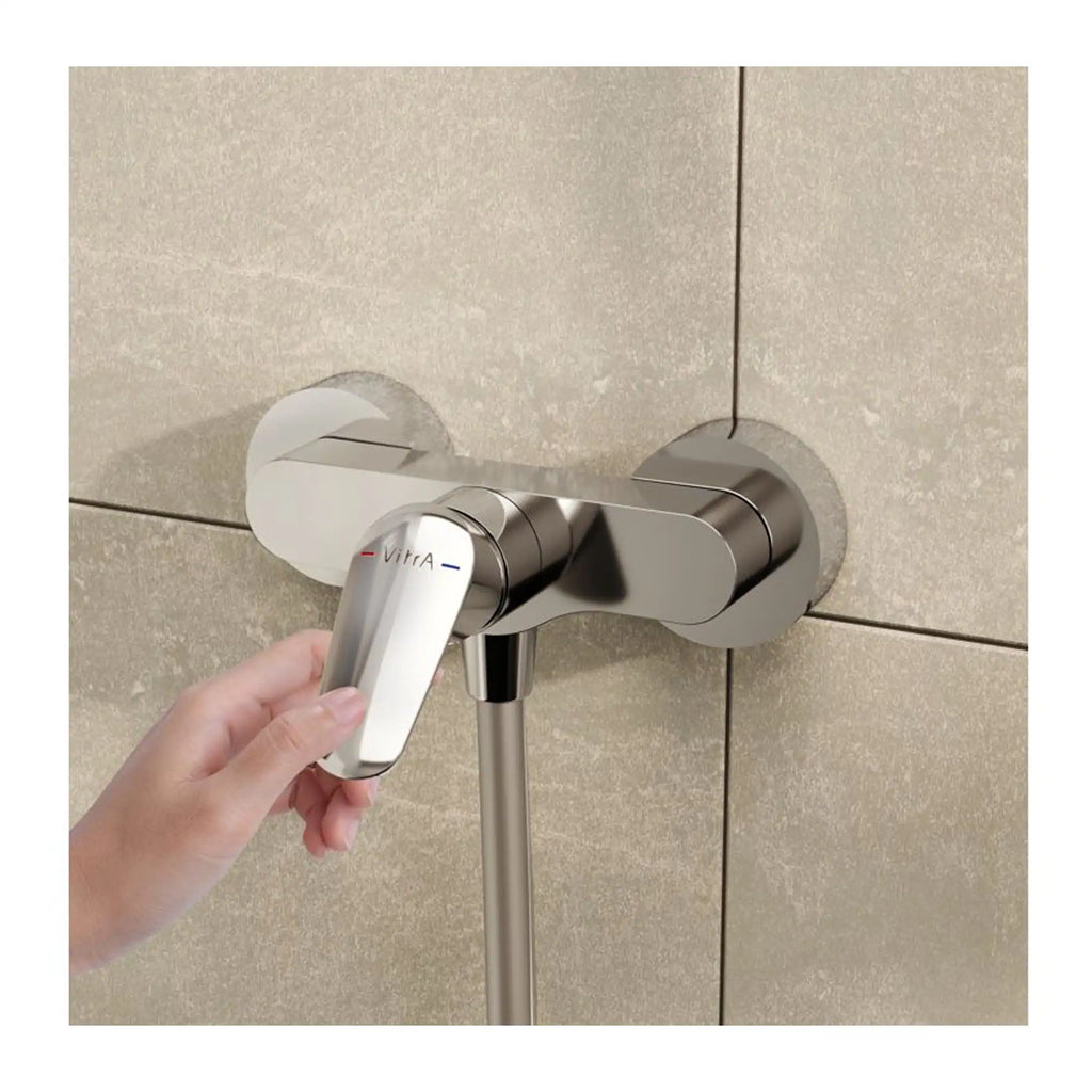 Sleek modern shower mixer tap with chrome finish set against beige tiled wall, designed for contemporary bathrooms. Features temperature and flow controls for a customised shower experience.