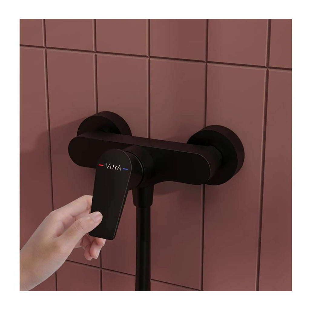 Sleek black Vitra thermostatic bathroom mixer tap with digital control, installed on pink tiled wall for modern bathroom design.