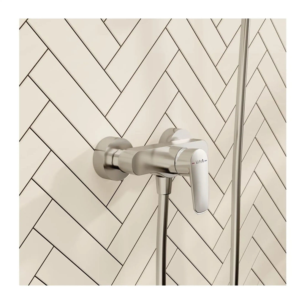 Sleek modern thermostatic shower valve with chrome finish on herringbone tiled bathroom wall. Professional installation of high-quality bath fixtures for contemporary bathroom designs.