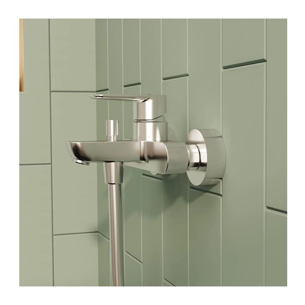 Modern stainless steel wall-mounted bathroom sink with sleek design and minimalist fixtures, set against a soft green tiled wall for a contemporary bathroom aesthetic.