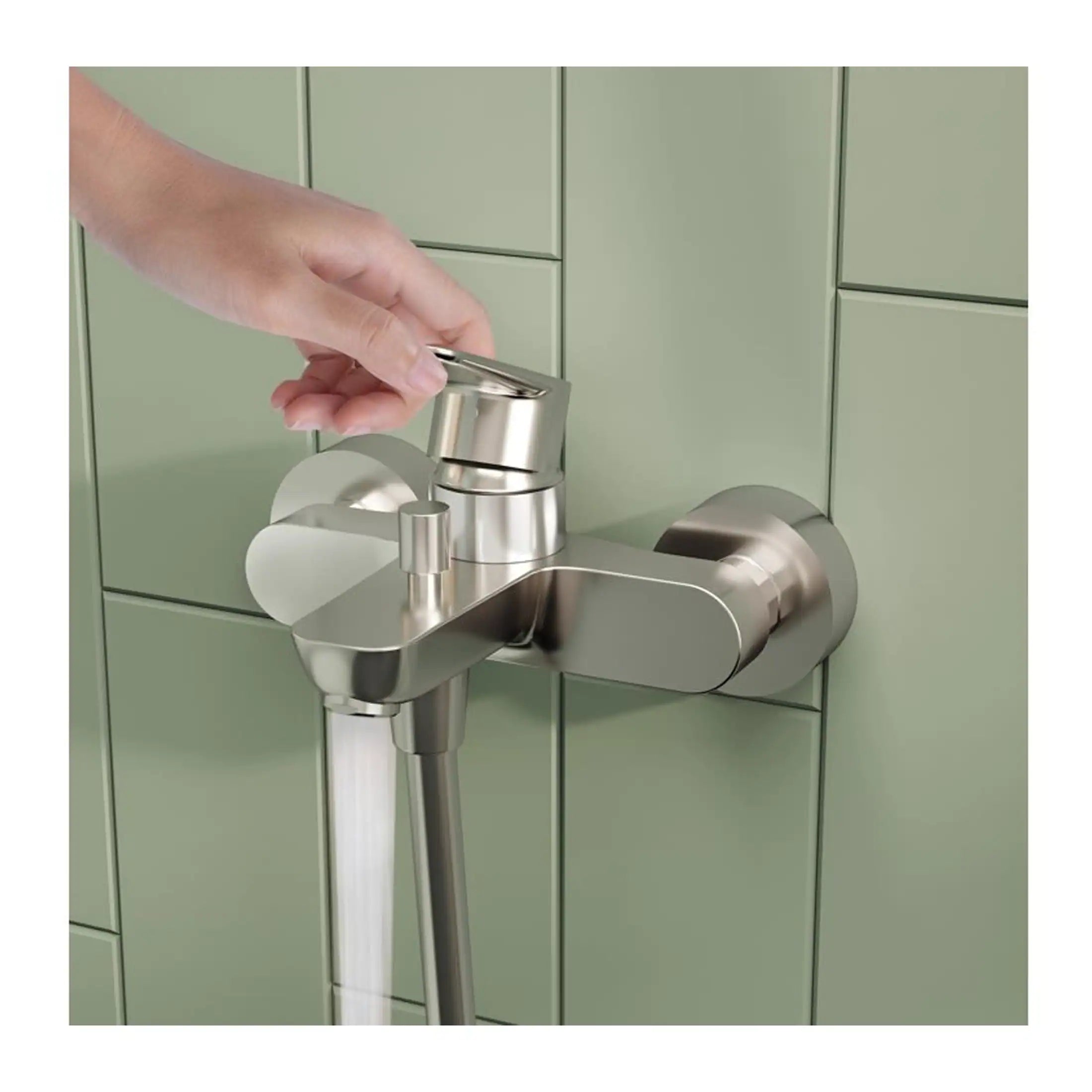 Shower tap with stainless steel finish and gentle water flow, installed on a green tiled wall, designed for modern and stylish bathroom interiors.