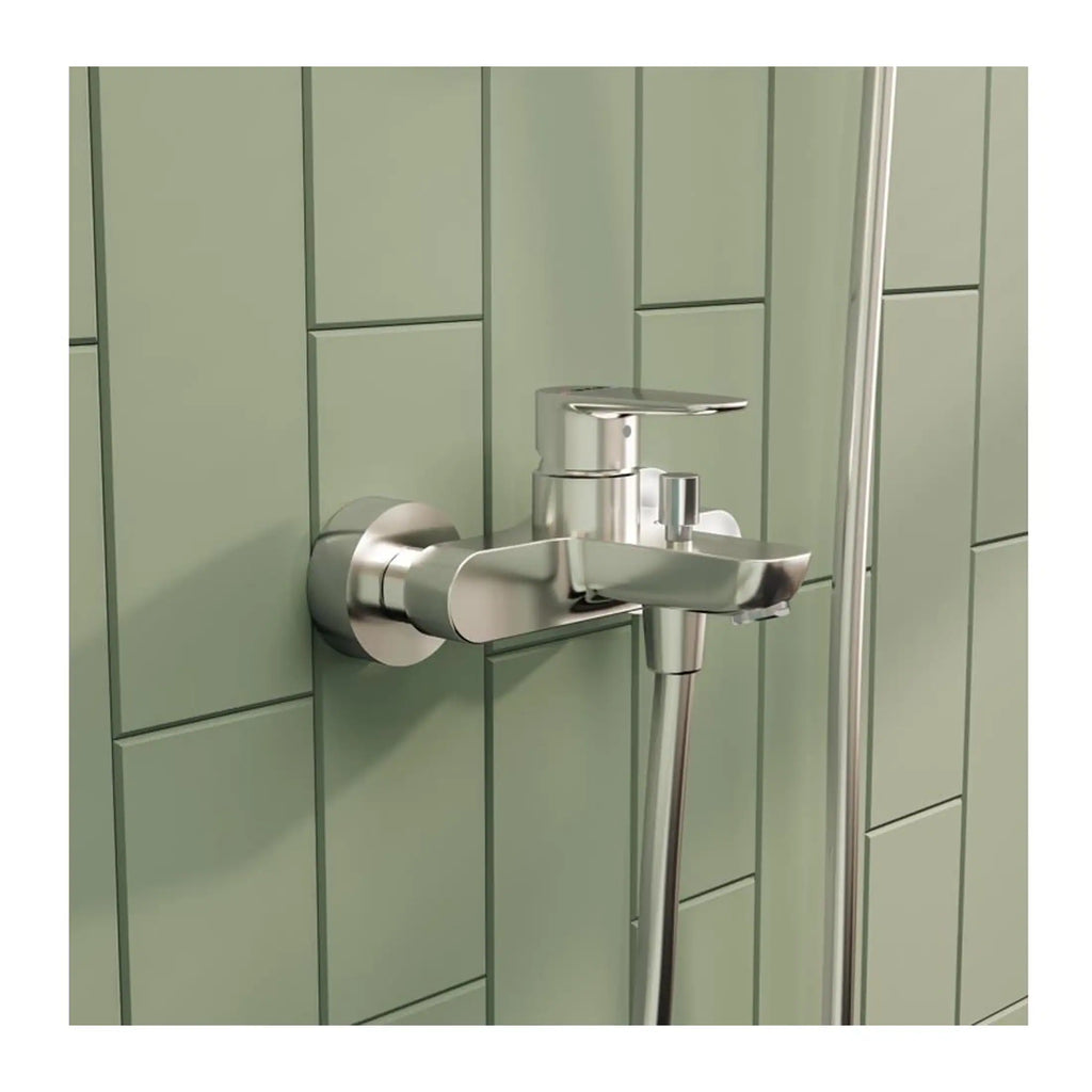 Sleek silver bathroom tap with modern design mounted on a green tiled wall in a contemporary bathroom setting.