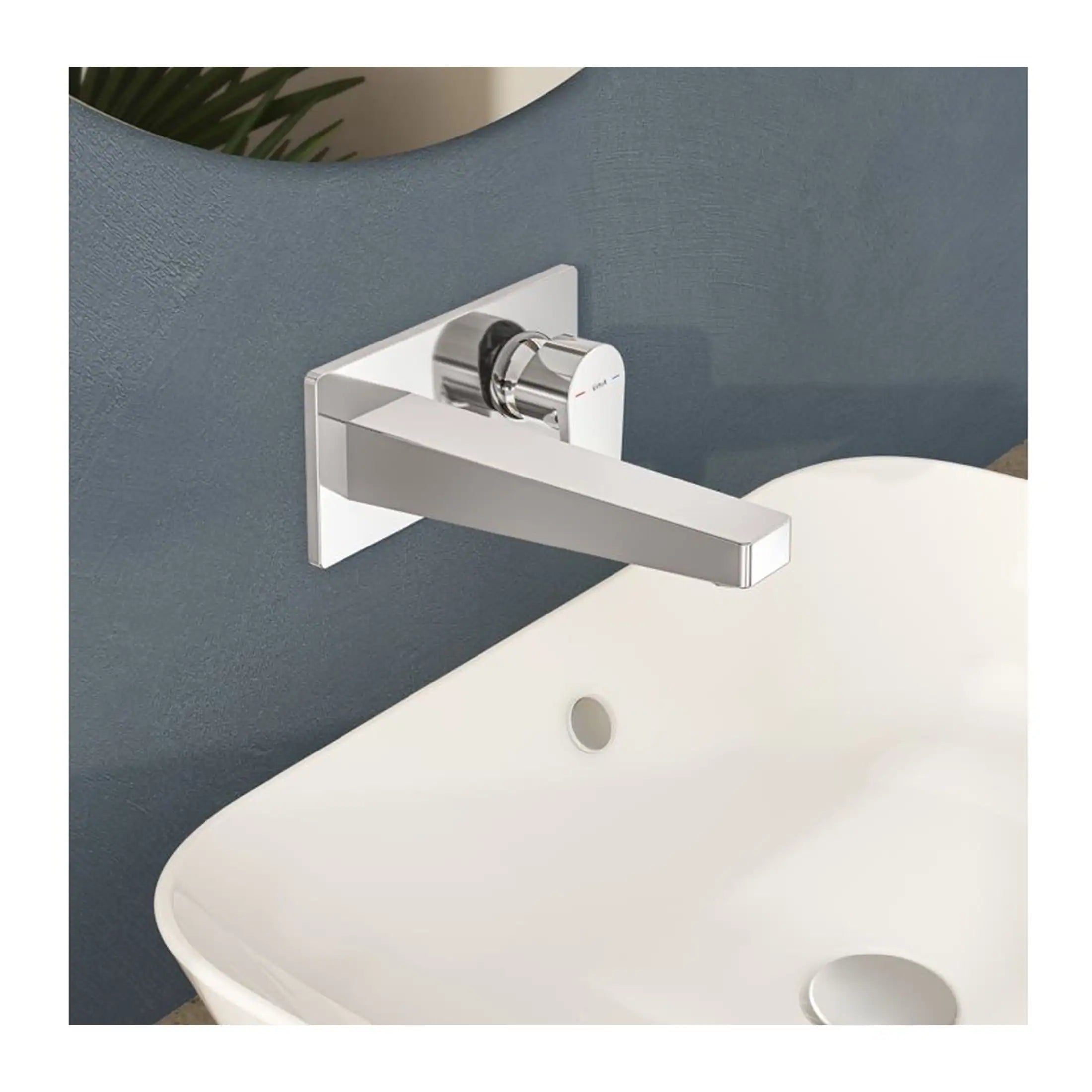 Sleek modern chrome bathroom tap mounted on a textured blue wall above a white ceramic sink, showcasing contemporary bathroom fixtures and stylish interior design.
