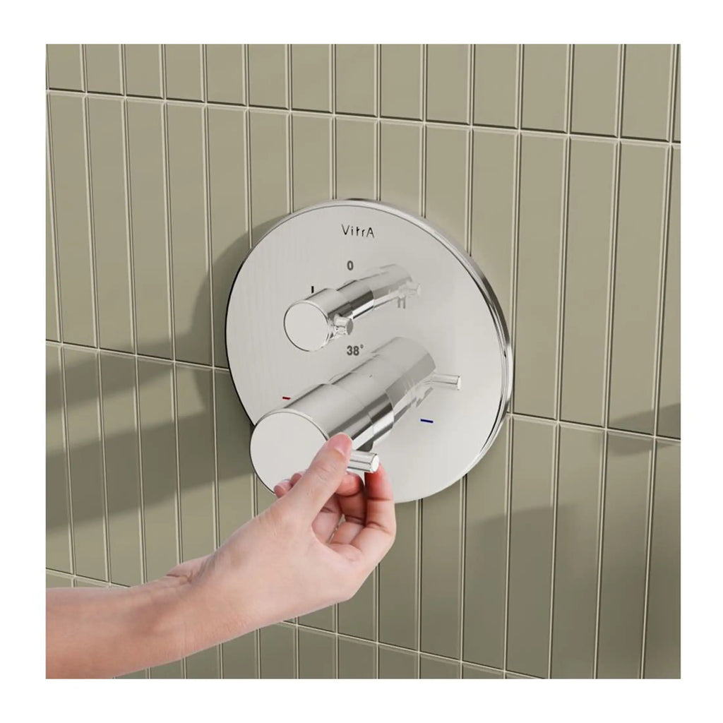Shower thermostatic mixing valve with dual controls on beige tiled bathroom wall for precise water temperature regulation.