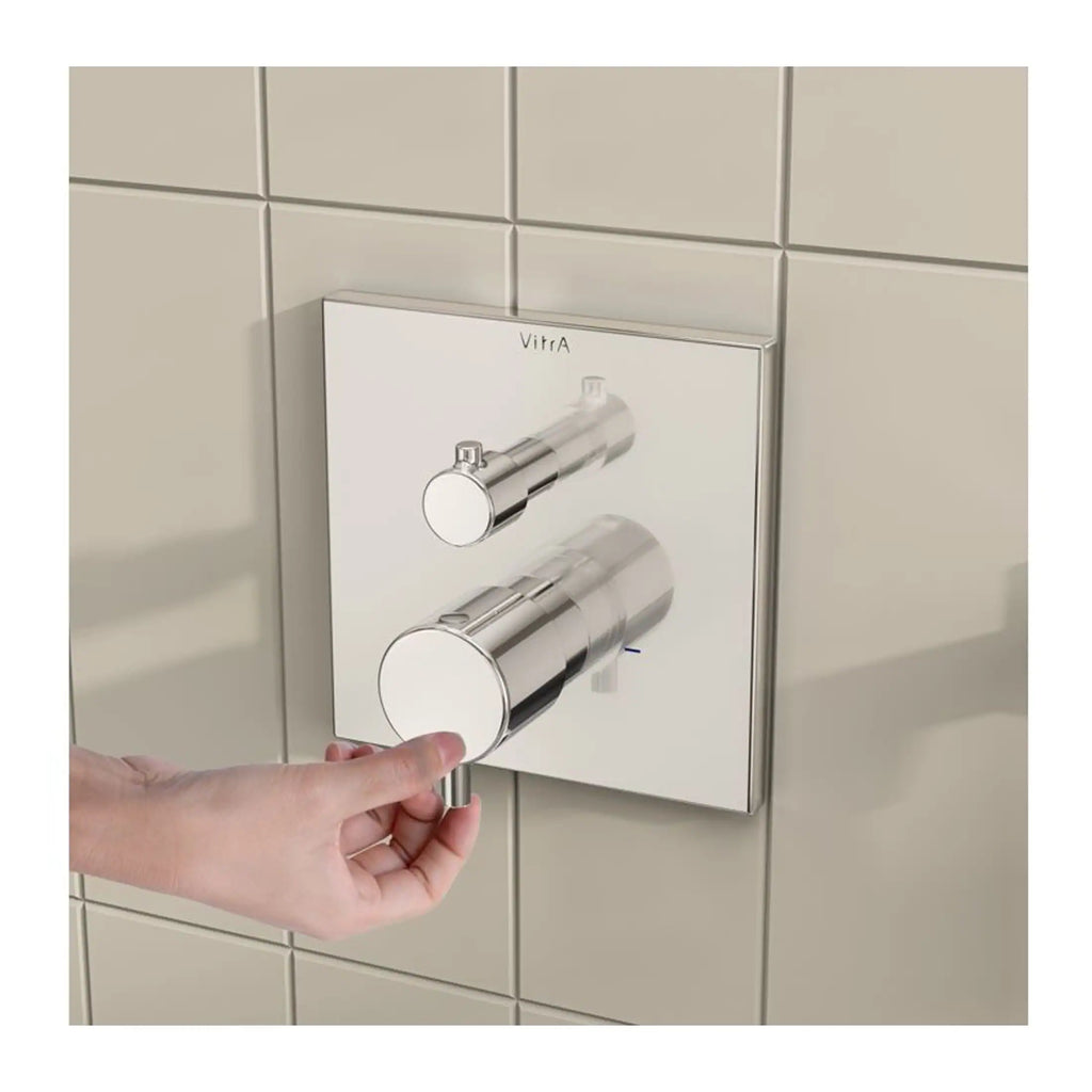 Chrome wall-mounted shower control valve with two adjustable knobs in a modern bathroom setting.