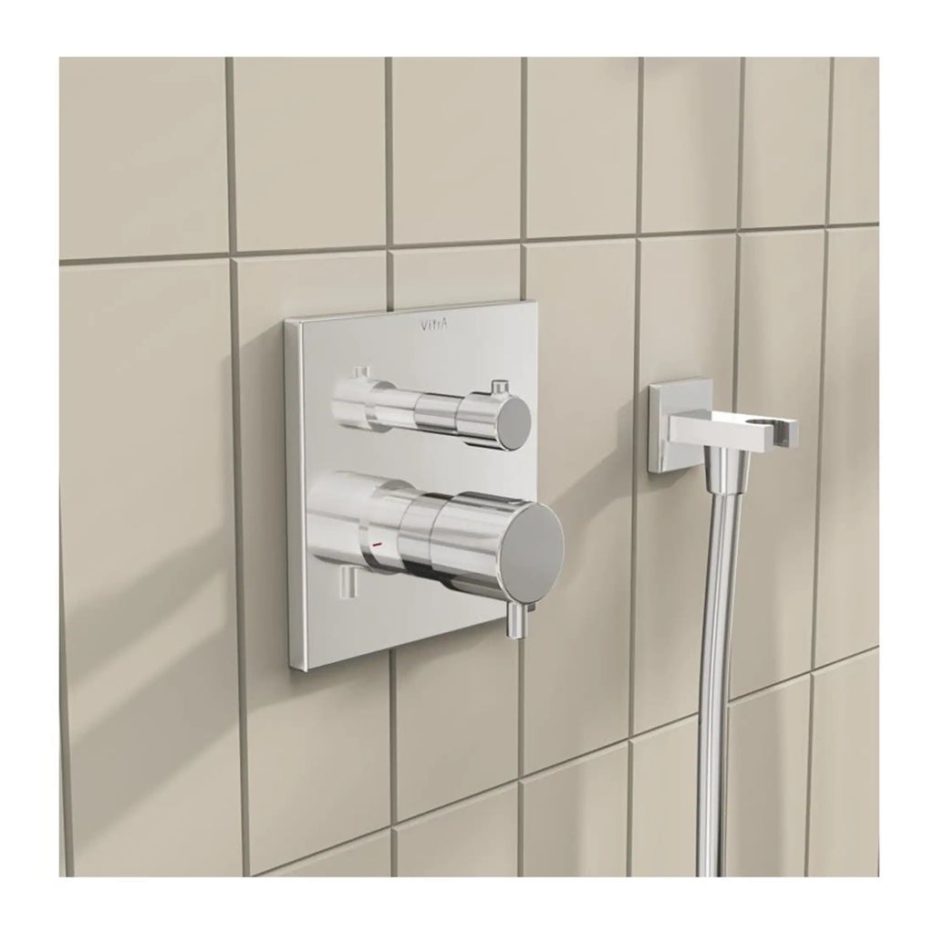 Sleek chrome bathroom mixer valve with wall-mounted controls and handheld shower head on beige tiled wall, designed for modern Bubly bathrooms.