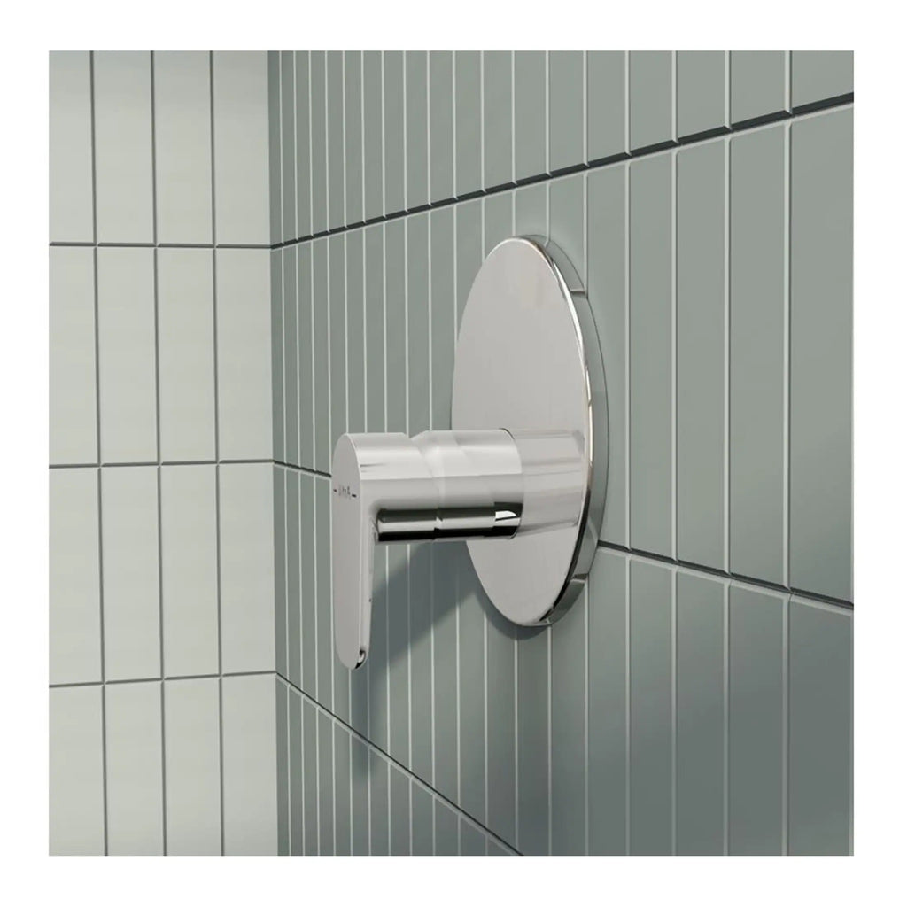 Modern stainless steel automatic hand dryer in a contemporary bathroom setting with grey tiled walls.