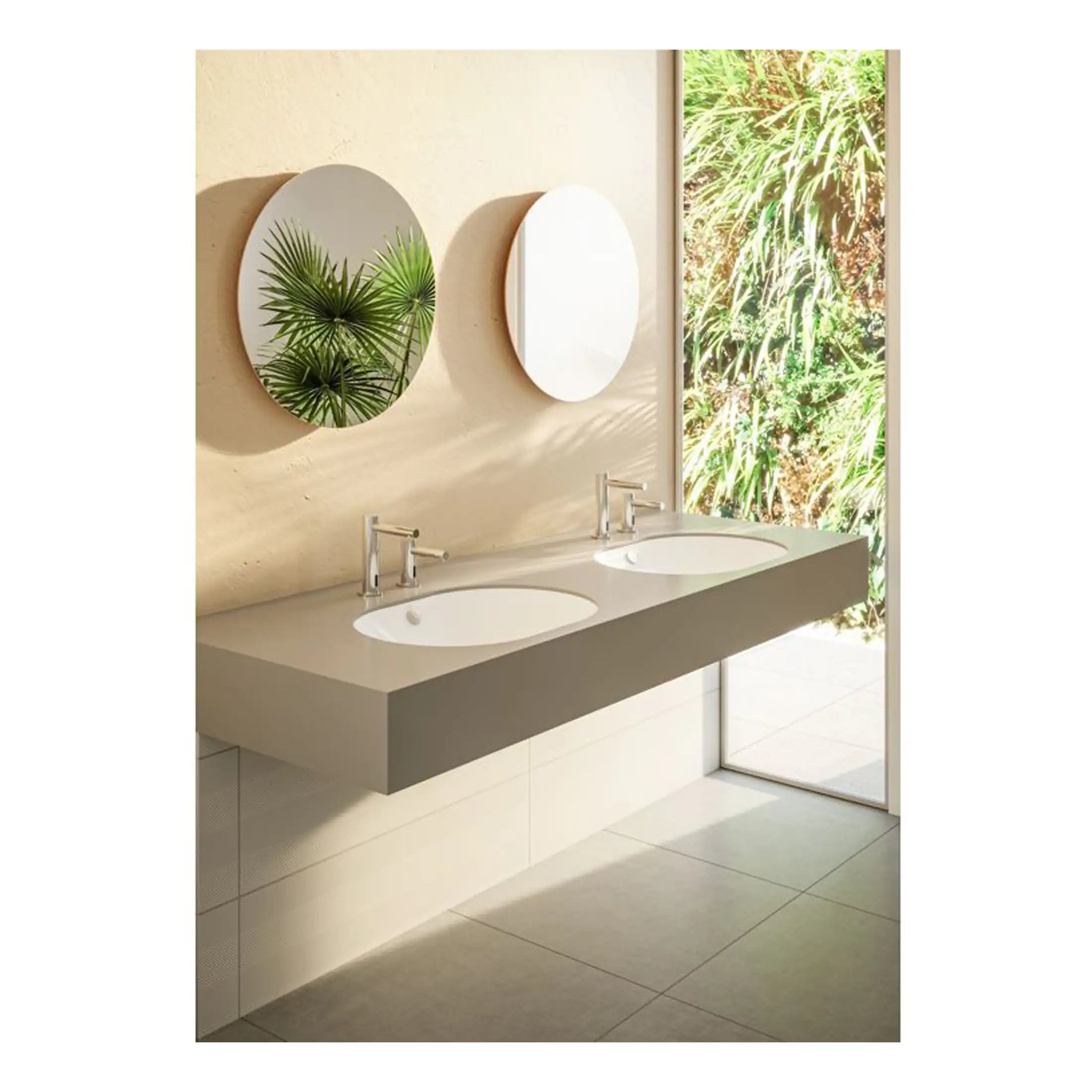 Modern double bathroom vanity with two oval sinks, sleek chrome faucets, and stylish round mirrors in a contemporary bathroom setting. Illuminated by natural light from a large window overlooking lush greenery.