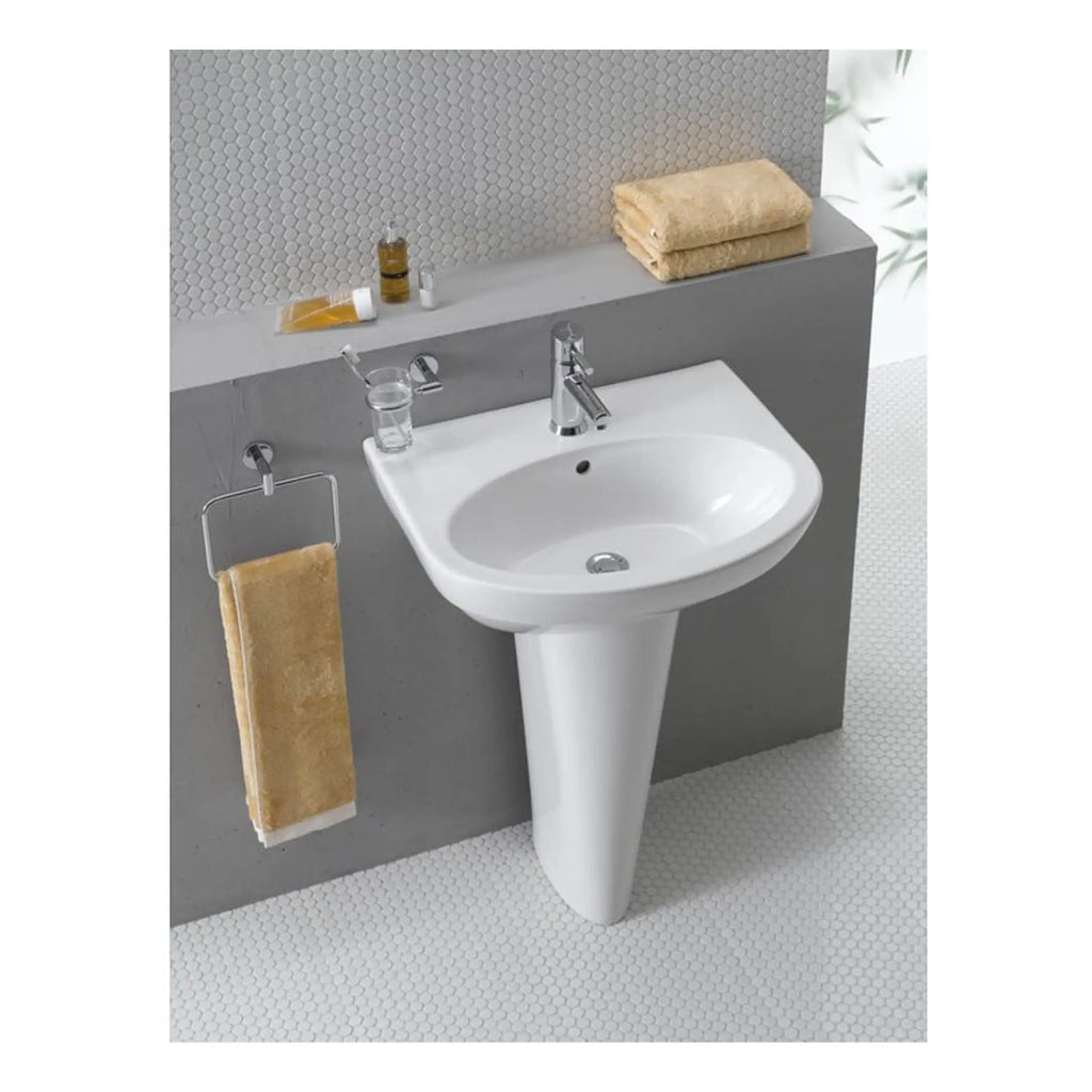 Bathroom sink with modern chrome faucet and beige towels, bathroom accessories, and textured wall tiles in a contemporary bathroom setup.