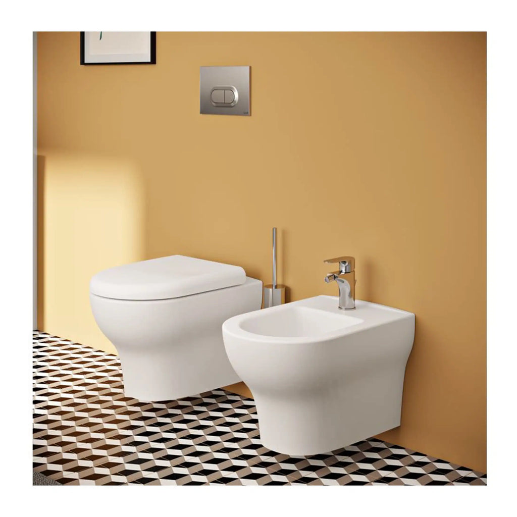Sleek modern bathroom with wall-mounted toilet and bidet, minimalist design, warm beige wall, stylish black and white patterned floor, chrome fixtures, ideal for contemporary bathroom renovations.