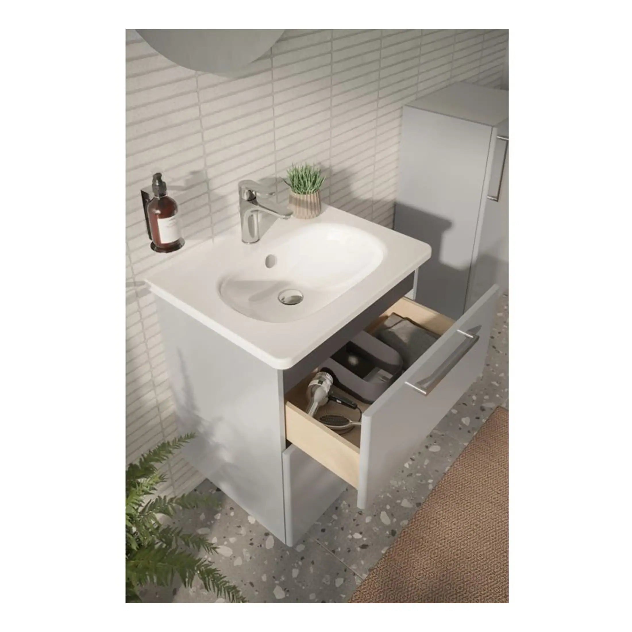 Sleek white bathroom vanity with modern chrome faucet, open drawer containing grooming tools, and decorative plant, ideal for contemporary bathroom designs.