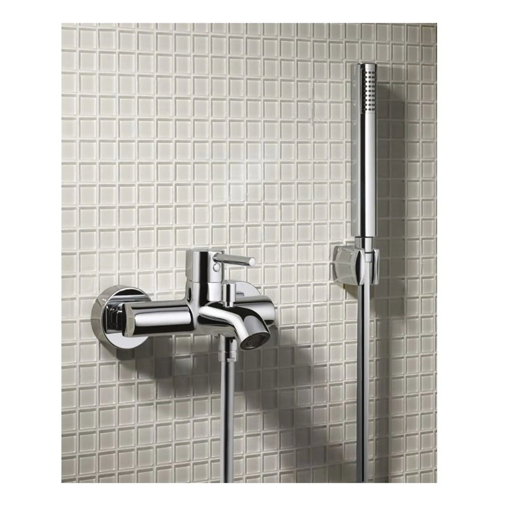 Shower mixer taps with handheld shower head mounted on tiled bathroom wall, modern chrome bathroom fixture for bathing.