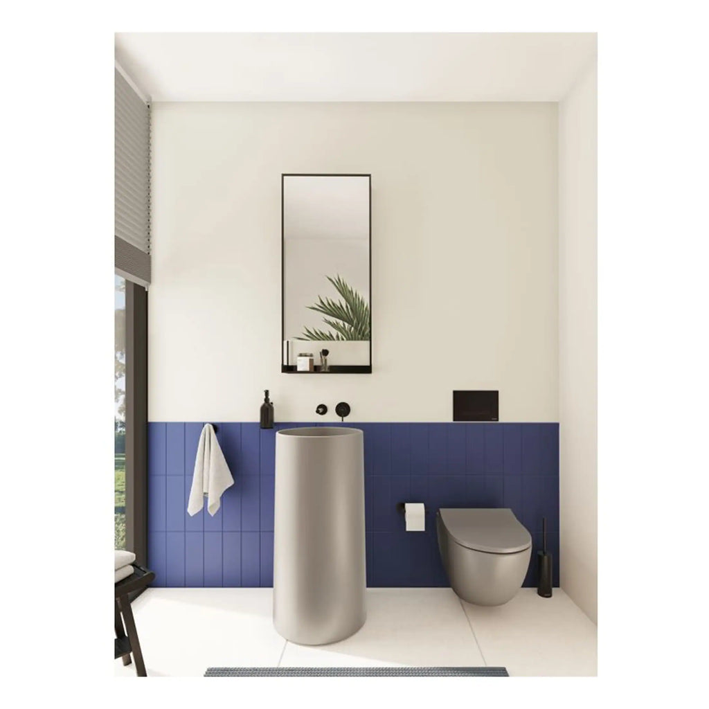 Sleek modern bathroom featuring blue tile wainscoting, a stylish grey toilet, minimalist black fixtures, and a tall cylindrical sink, creating a contemporary and functional space.