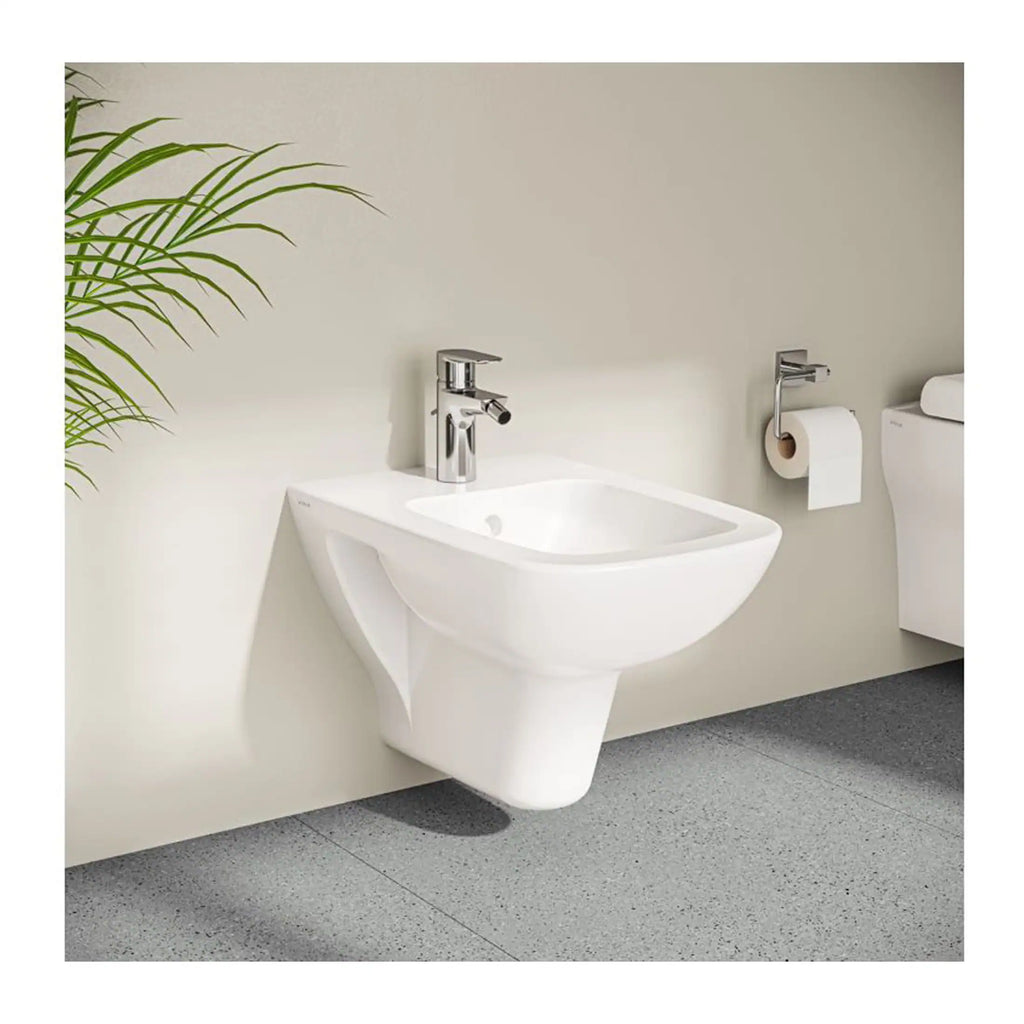 Polished white wall-mounted bathroom bidet with chrome mixer tap, modern minimalist design, ideal for contemporary bathroom spaces, with grey tiled flooring and a nearby toilet.