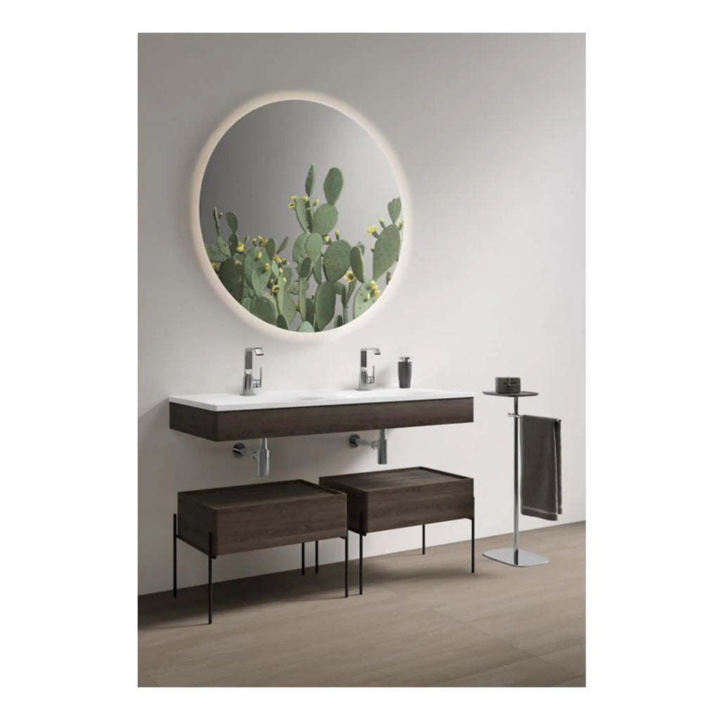 Smooth modern bathroom vanity with dual sinks, wooden cabinetry, and large round mirror reflecting a cactus picture, creating a sleek, contemporary space.