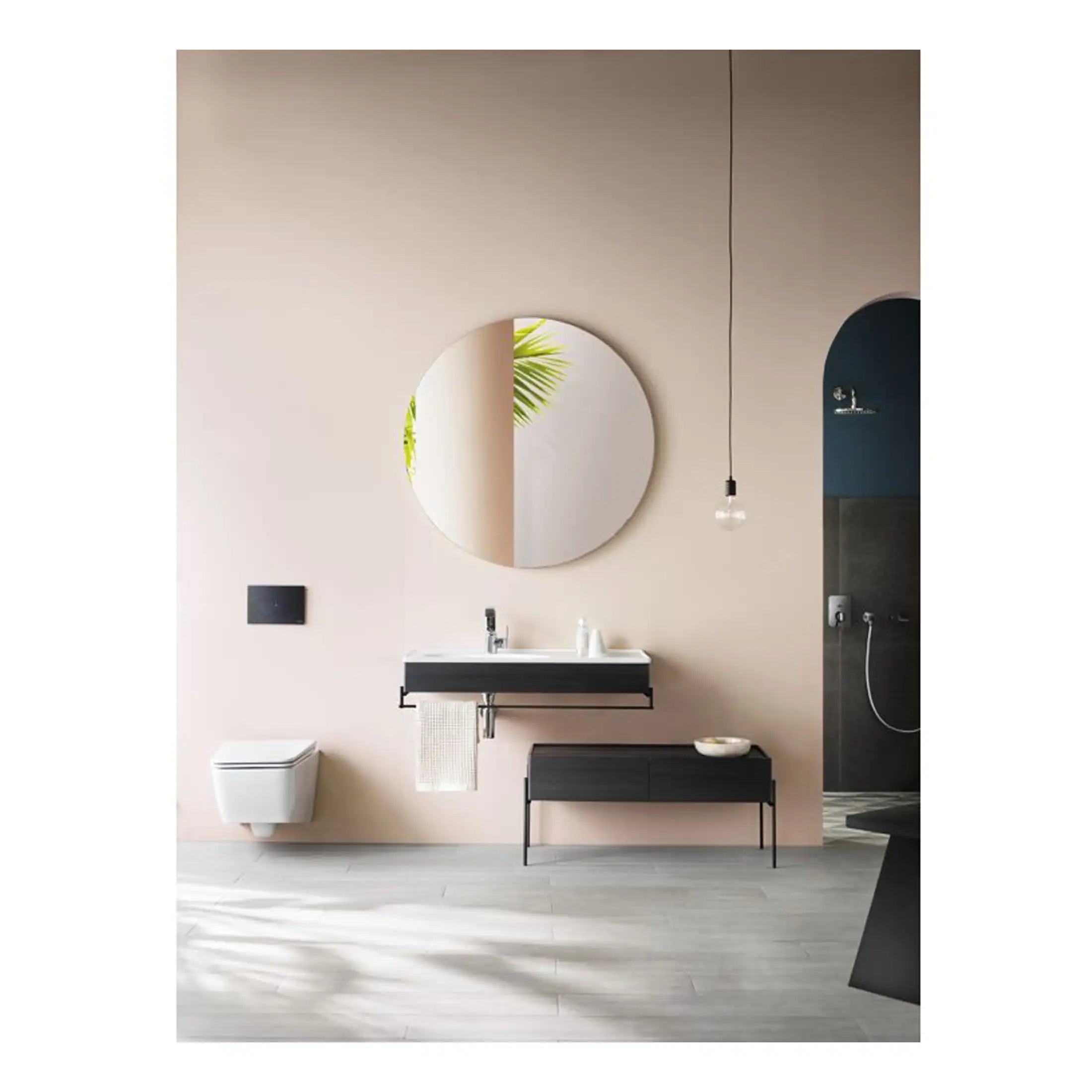 Sleek modern bathroom with minimalist design, featuring a black and white floating vanity, round mirror, wall-mounted toilet, and open shower area for a contemporary aesthetic.