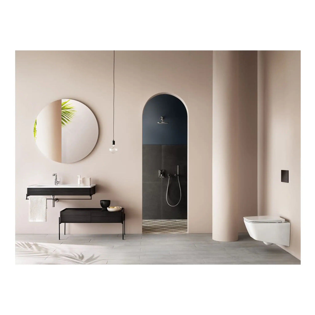 Sleek modern bathroom with a stylish wall-mounted sink, large round mirror, walk-in shower featuring dark tiles, and contemporary toilet, all designed with minimalist aesthetics.