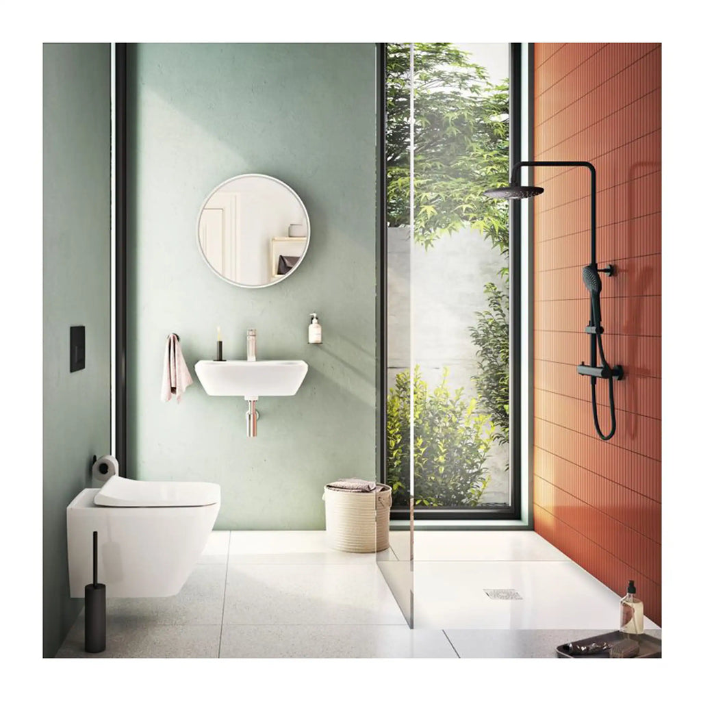 Modern minimalist bathroom with floating sink, wall-mounted toilet, circular mirror, large window with greenery, and a sleek walk-in shower with black fixtures and terracotta accent wall, creating a bright and airy space.