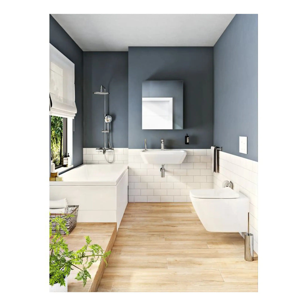 Modern bathroom with white bathtub, wall-mounted sink, and toilet, featuring navy blue walls, white subway tiles, wooden flooring, and natural light from a window, showcasing stylish Bubly Bathrooms fixtures.