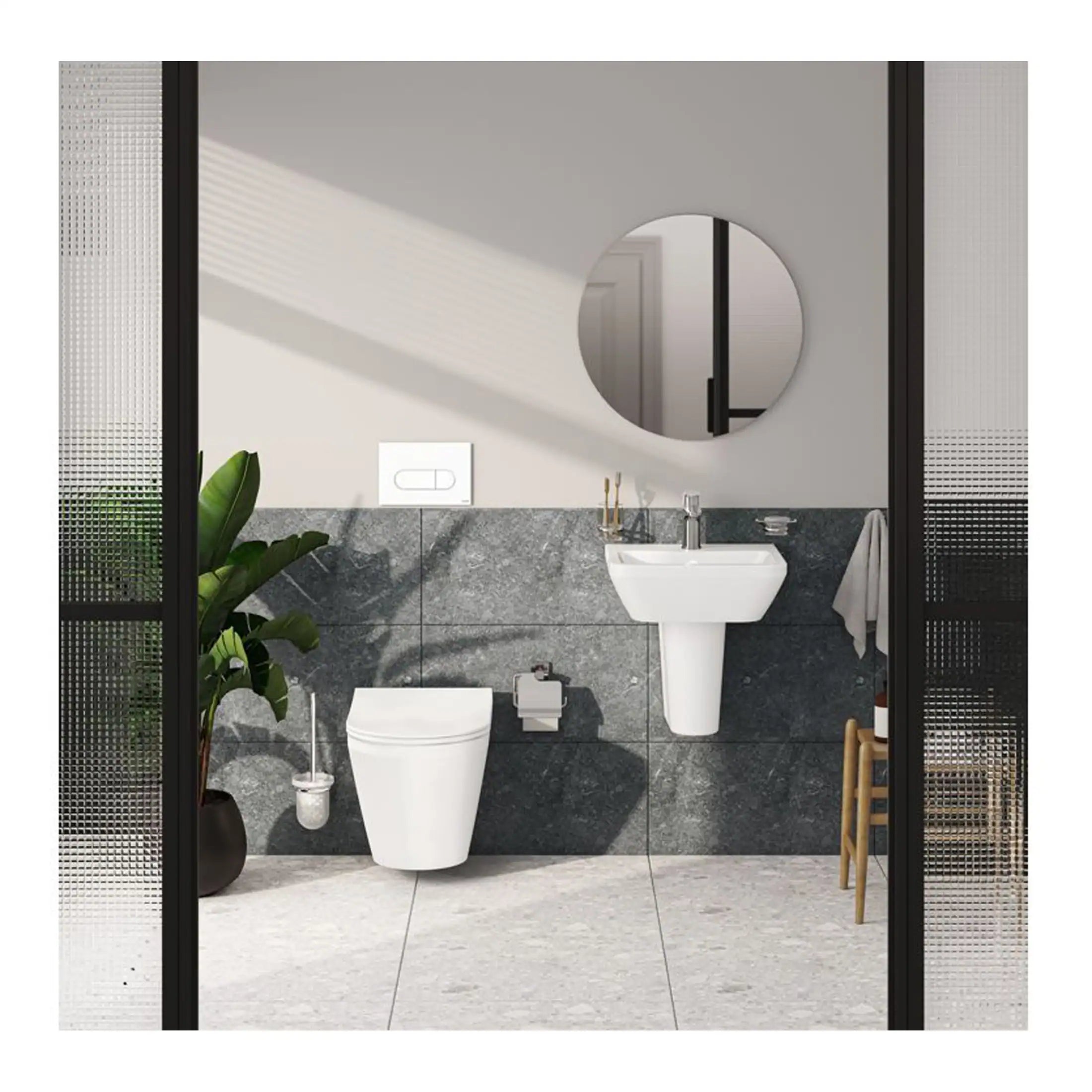 Sleek modern bathroom featuring a wall-mounted toilet, pedestal sink, and circular mirror with natural light. Elegant grey tiled walls and minimalist design create a stylish space.