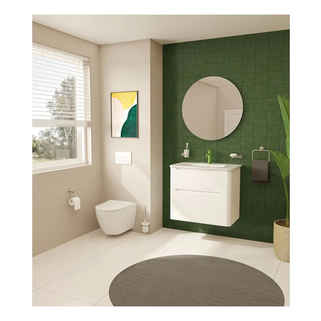 Modern bathroom with green tiled accent wall, white floating vanity, round mirror, wall-mounted toilet, and natural light from large window, creating a sleek and contemporary space.