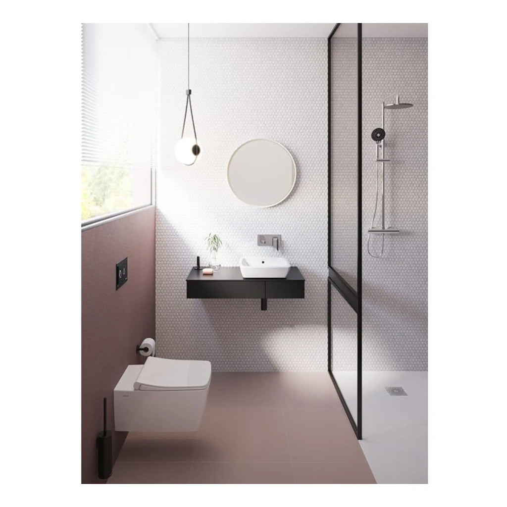Contemporary minimalist bathroom with sleek black floating vanity, modern sink, round mirror, walk-in shower with glass enclosure, and soft pink wall accents, perfect for stylish bathroom renovations.
