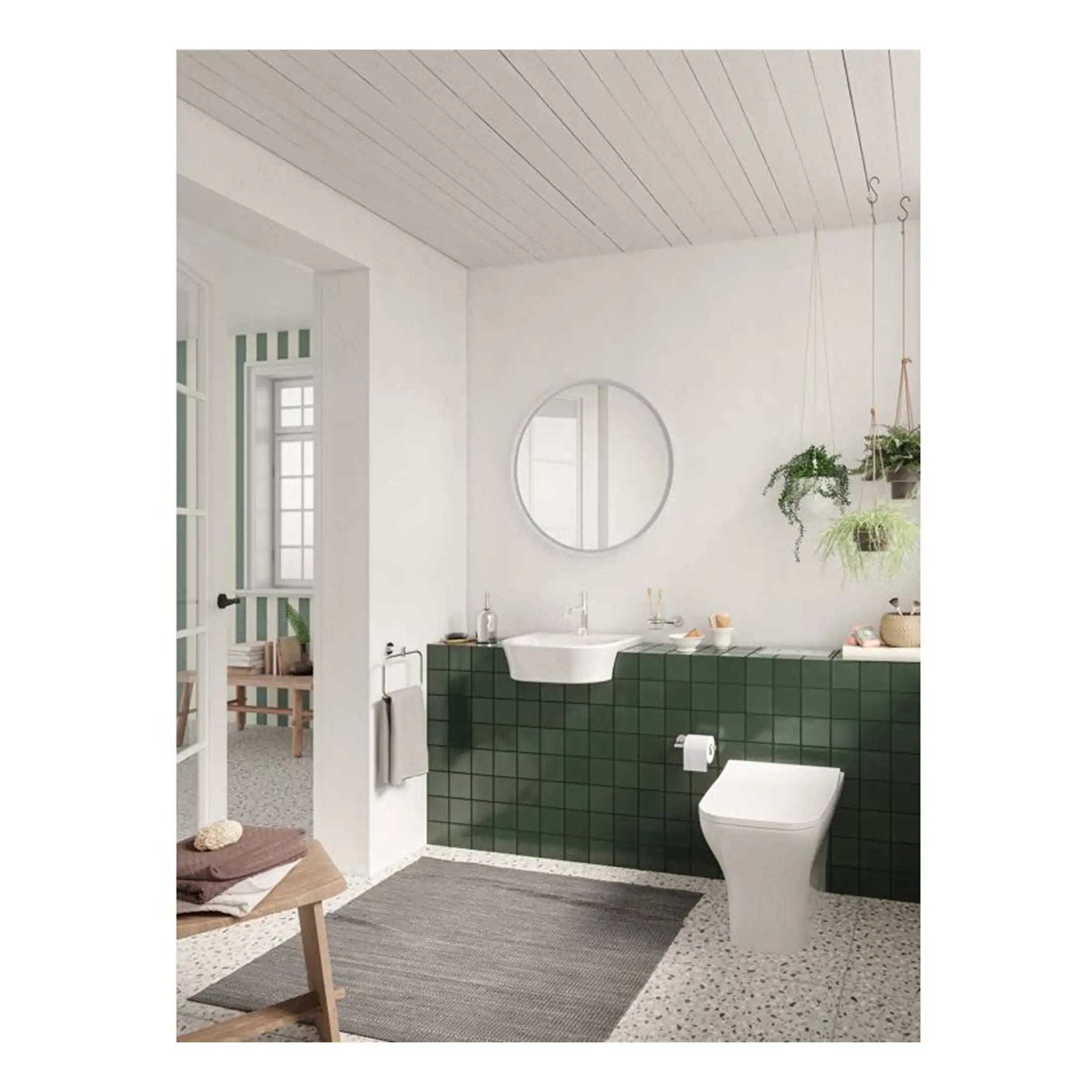 Modern bathroom with green tiled wall, white ceramic sink, and contemporary toilet, featuring hanging plants and natural light for a stylish, eco-friendly bathroom design.